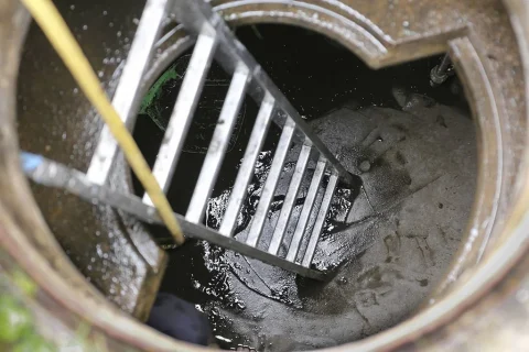 Plumber cleaning sediment from a household water tank in Tokha